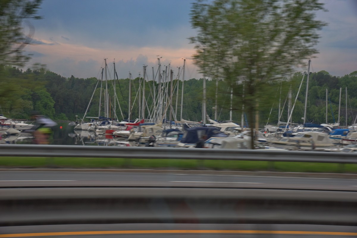 Пригород Осло. Много яхт на воде.  Норвегия. Вид из окна машины.